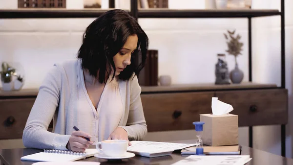 Serious Woman Sitting Table Reading Documents Notebook Pen Hand Home — Stock Photo, Image