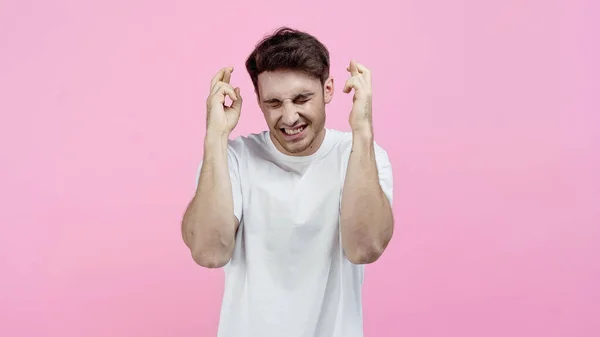 Homem Sorridente Com Olhos Fechados Mostrando Dedos Cruzados Isolados Rosa — Fotografia de Stock