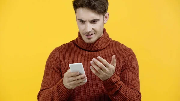 Zdezorientowany Mężczyzna Trzymający Telefon Komórkowy Żółtym — Zdjęcie stockowe