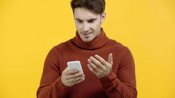 Homem Confuso Segurando Celular Isolado Amarelo — Fotografia de Stock