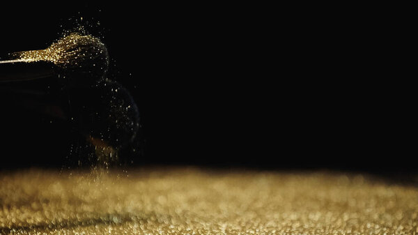 косметические кисти с блестящими золотыми блестками на черном фоне