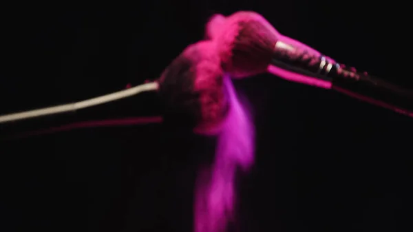 Blurred Cosmetic Brushes Making Explosion Pink Powder Black Background — Stock Photo, Image