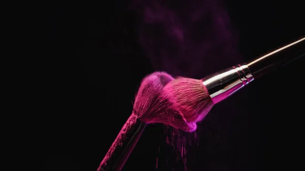 Cosmetic Brushes Bright Pink Holi Powder Hitting Black Background — Stock Photo, Image