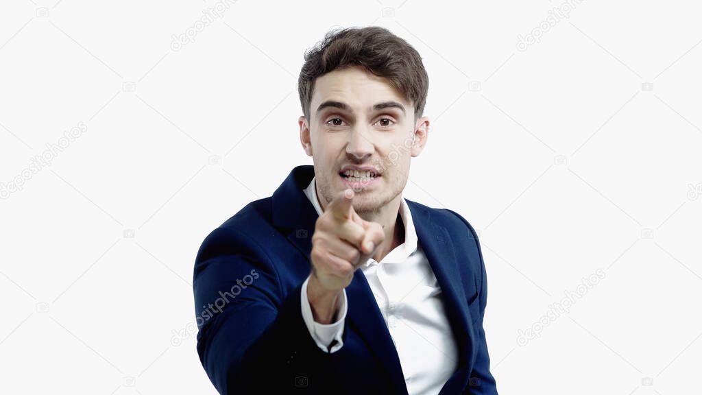 Angry businessman pointing with finger at camera on blurred foreground isolated on white 