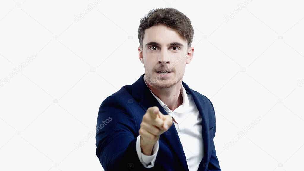 Irritated businessman pointing at camera isolated on white 