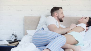 Mutlu sakallı adam örgülü neşeli kız arkadaşına sarılıyor. 