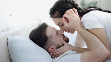 Genç çift birbirine bakıyor ve yüzlerine dokunuyor. 