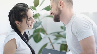 Evlerinde birbirlerine bakan neşeli genç bir çift.