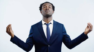 Gözü kapalı Afro-Amerikan işadamı mavi üzerine meditasyon yapıyor.