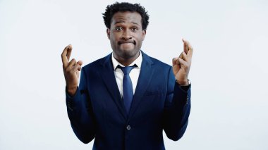 Takım elbiseli Afro-Amerikan iş adamı. Parmakları çapraz mavi.