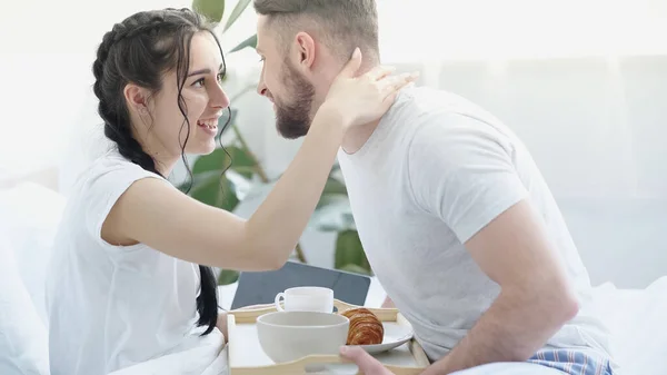 快乐的女朋友 辫子拥抱着快乐的男人 带着早餐盘在床上 — 图库照片