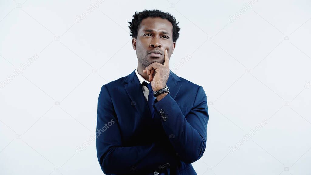 pensive african american businessman in formal wear thinking isolated on blue