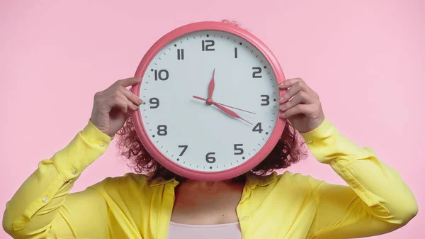 Young Woman Covering Face While Holding Clock Isolated Pink — Stock Photo, Image