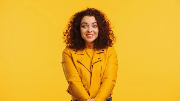 Utangaç ve gülümseyen deri ceketli genç bir kadın.