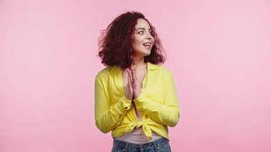 Neşeli genç bir kadın pembe üzerinde el çırpıyor. 