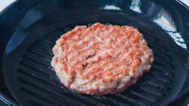 close up of formed mince patty on grill pan clipart