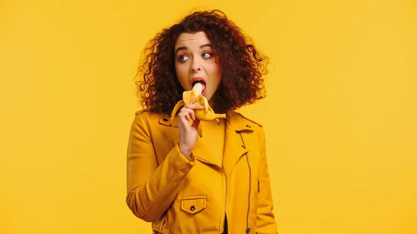 Joven Mujer Rizada Chaqueta Cuero Comiendo Plátano Aislado Amarillo —  Fotos de Stock