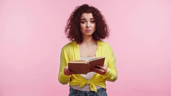 Kudrnatý Smutný Student Drží Knihu Izolovanou Růžové — Stock fotografie