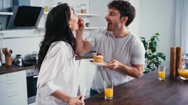 Cheerful Man Holding Pancakes Feeding Girlfriend Raspberry Kitchen — Stock Photo, Image