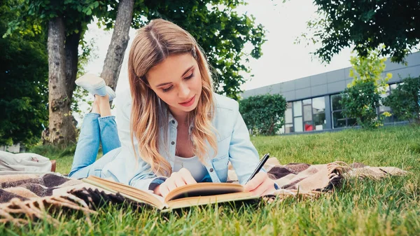 Studente Che Scrive Mentre Giace Sulla Coperta Vicino Libro Nel — Foto Stock