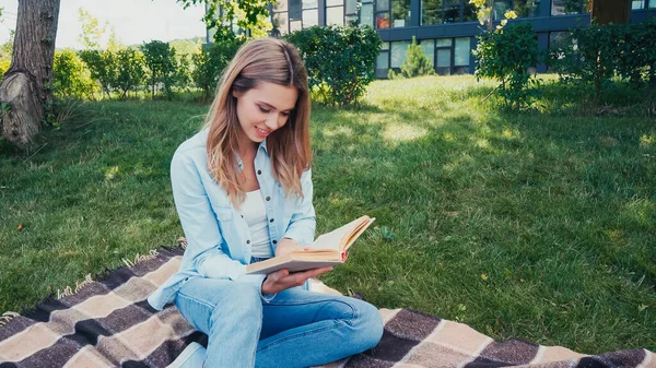 Sorridente Giovane Donna Seduta Coperta Lettura Libro Nel Parco — Foto Stock