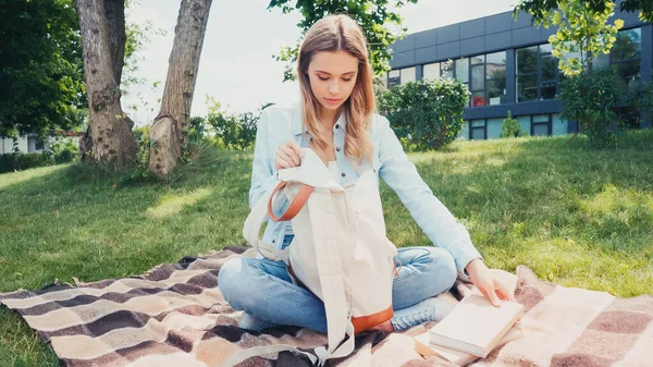 Young Student Packing Books Backpack Plaid Blanket Park — Stock Photo, Image