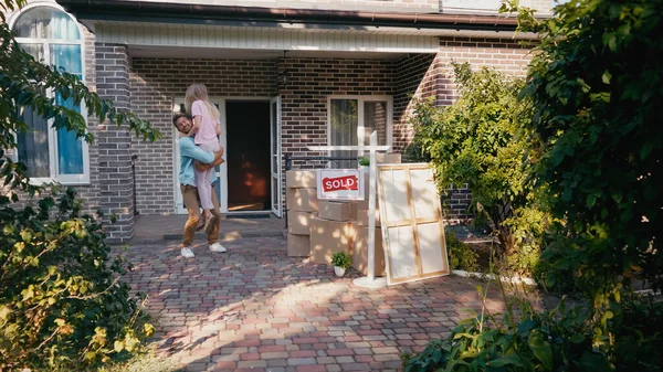 Homem Feliz Levantando Esposa Perto Caixas Nova Casa — Fotografia de Stock