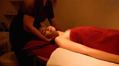 Kapalı gözlü müşteri spa salonundaki masörden boyun masajı alıyor.