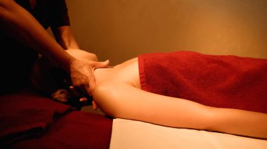 Genç bir kadın spa salonundaki profesyonel masörden boyun masajı alıyor.