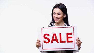 Gülümseyen simsar, beyaz üzerine izole edilmiş satılık harflerle panoya bakıyor.