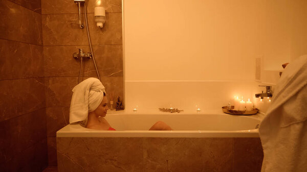 side view of cheerful woman in bathtub with water in wellness center