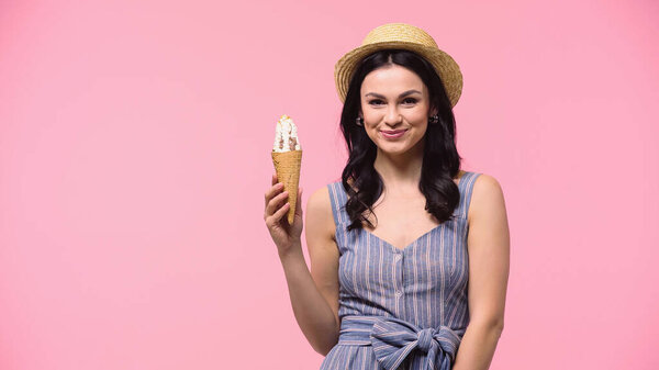 Pretty woman in sun hat holding ice cream isolated on pink 