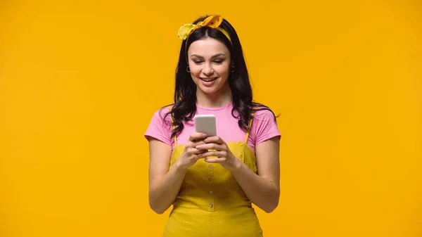 Young Woman Smiling While Using Smartphone Isolated Yellow — 스톡 사진