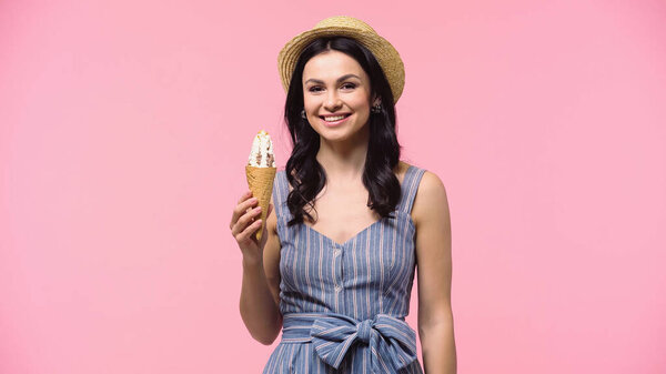Pretty woman holding ice cream in waffle cone isolated on pink 