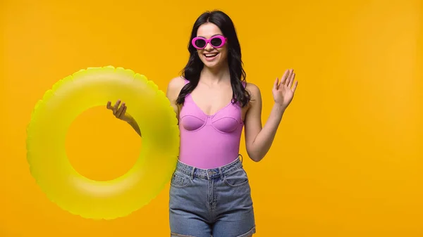 Smiling Woman Sunglasses Holding Swim Ring Waving Hand Isolated Yellow — 스톡 사진