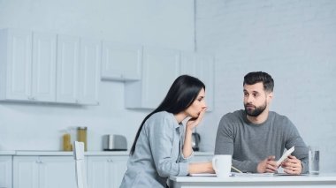 Sakallı adam hesap makinesini kadınlara gösteriyor 