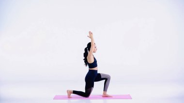 Çıplak ayaklı bir kadının beyaz bir yoga minderi üzerinde egzersiz yapması.