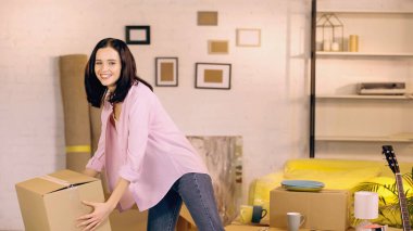 happy woman taking carton box in new home  clipart