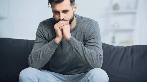 Worried Man Grey Sweater Sitting Clenched Hands Couch — Stock Photo, Image