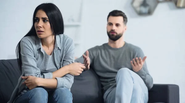 Frustrated Woman Sitting Blurred Displeased Boyfriend Quarrelling Living Room — 스톡 사진