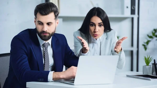 Sad Businessman Looking Away While Businesswoman Quarrelling Pointing Laptop — 스톡 사진