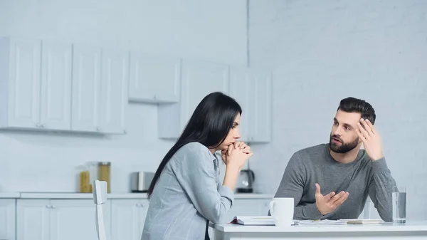 Man Gesturing While Discussing Finances Woman Kitchen — 스톡 사진