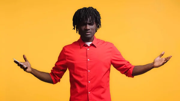 Displeased African American Man Holding Smartphone Gesturing Isolated Yellow — Stock Photo, Image