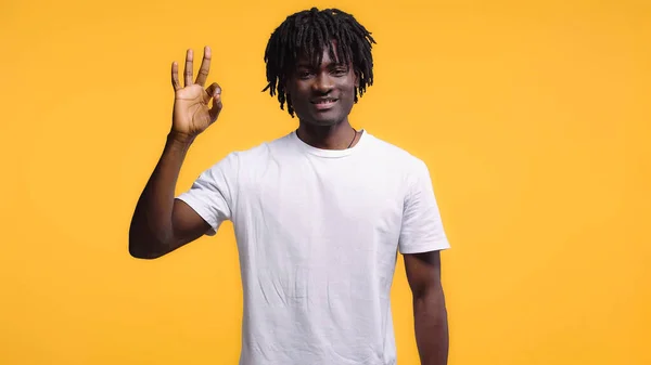 Afrikanischer Mann Lächelt Und Zeigt Zeichen Isoliert Auf Gelb — Stockfoto