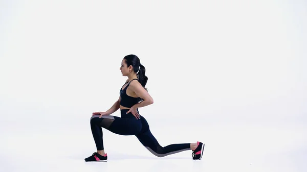 Mujer Joven Flexible Ropa Deportiva Haciendo Embestidas Blanco — Foto de Stock