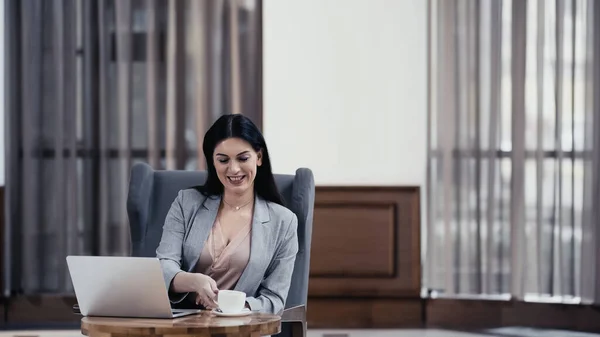 Cheerful Freelancer Reaching Cup Coffee Laptop Table Restaurant — Stock fotografie