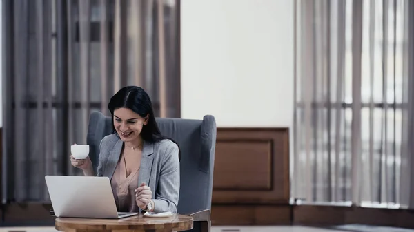 Cheerful Freelancer Holding Cup Coffee Looking Laptop Table Restaurant — Stock fotografie