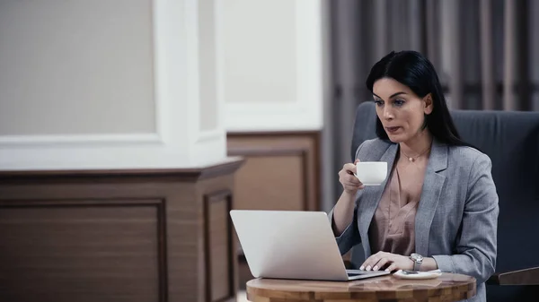 Woman Holding Cup While Looking Laptop Restaurant — Stock fotografie