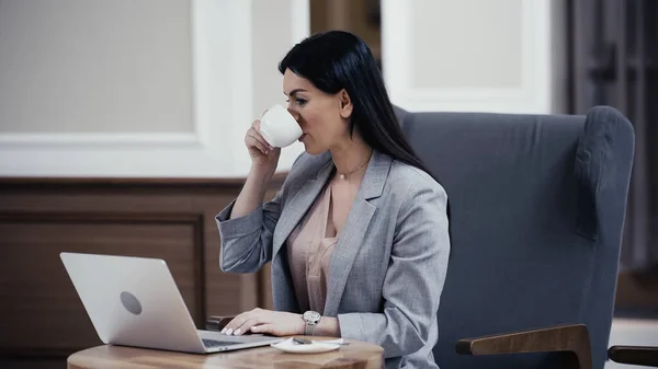 Frau Trinkt Kaffee Beim Blick Auf Laptop Restaurant — Stockfoto