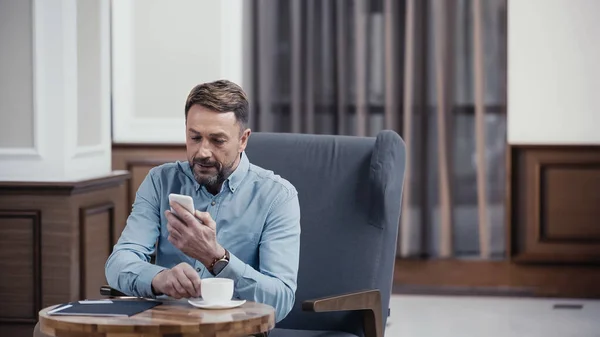 Businessman Using Smartphone Reaching Cup Coffee Lobby Restaurant — Stock Photo, Image